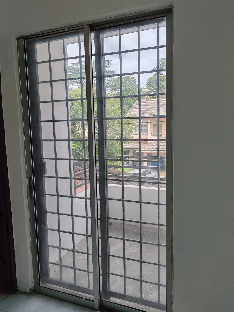 Room features: sliding glass door, grid pattern window, white walls, tile flooring, view of outdoor balcony, natural light; view: garden.